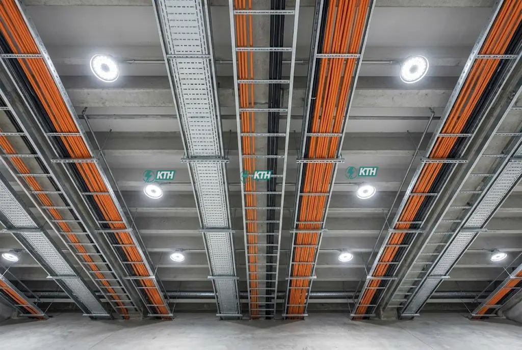 Thi Công Điện Nhà Xưởng: Quy Trình & Báo Giá Chi Tiết 2025 4 Hệ thống thang máng cáp điện động lực được lắp đặt thẳng hàng, chắc chắn trên trần nhà xưởng công nghiệp.