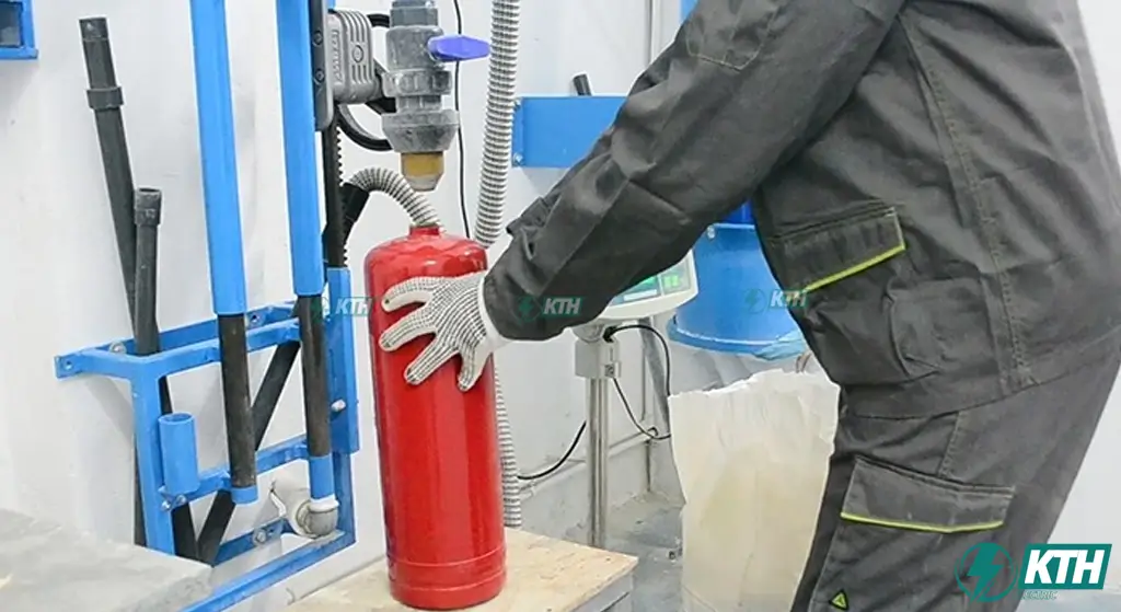 Kỹ thuật viên chuyên nghiệp tại KTH Electric thực hiện quy trình nạp sạc bình chữa cháy bột ABC chuẩn TCVN 3890 cho khách hàng tại TP Hồ Chí Minh.